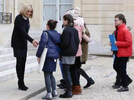 Brigitte Macron en pull long, jupe courte et bottes accueille les enfants de l'Unicef à l'Elysée