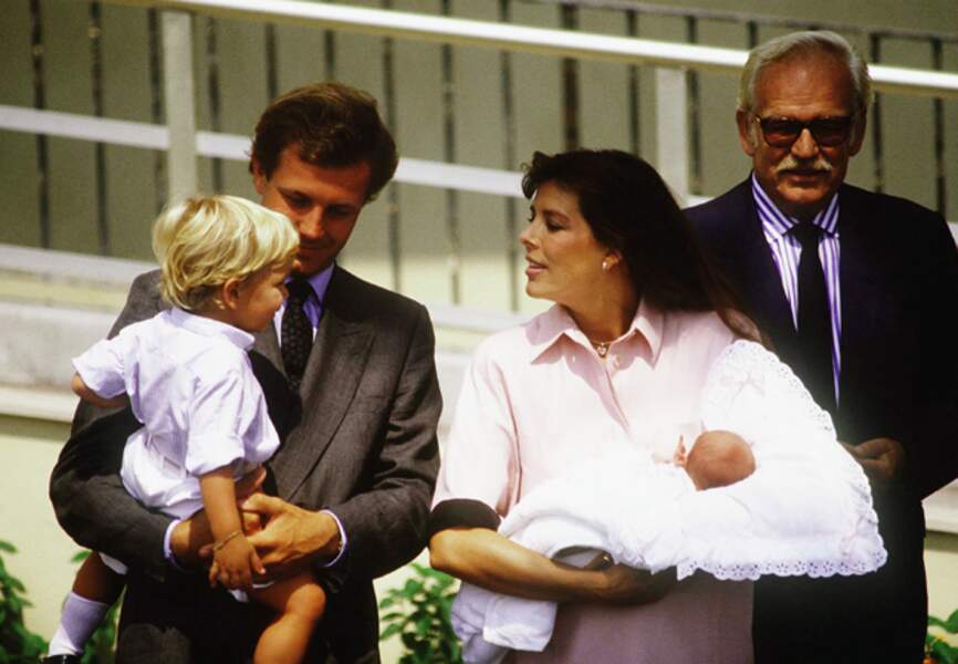 Andrea dans les bras de son père regarde la petite Charlotte dans les bras de sa maman Caroline
