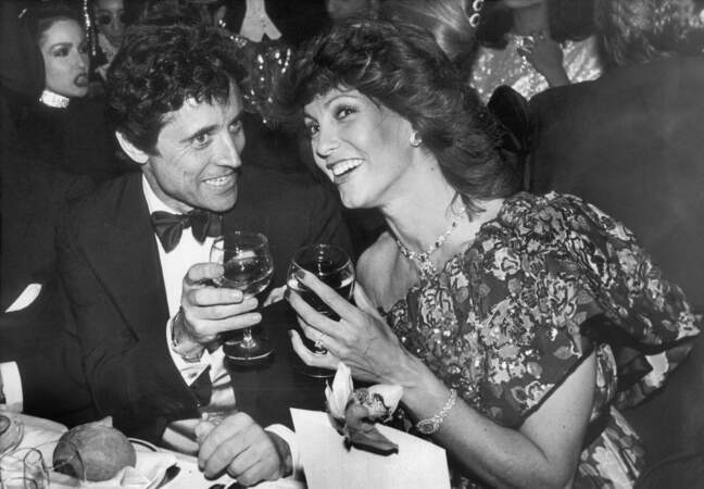 Sacha Distel en 1985, un verre à la main, profite du Lido au côté de l'actrice Chantal Nobel