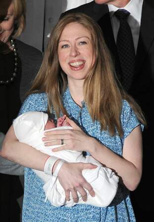La jeune maman de 34 ans pose devant le flash des photographes son bébé dans les bras