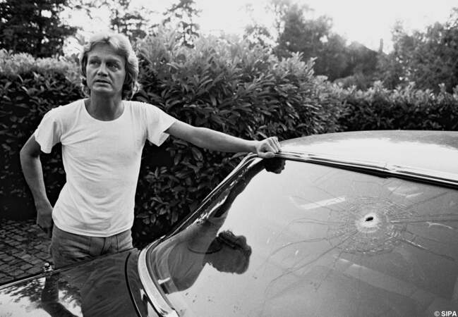 Claude François montre l'impact de balle sur sa voiture, après avoir été pris pour cible par un homme en 1977