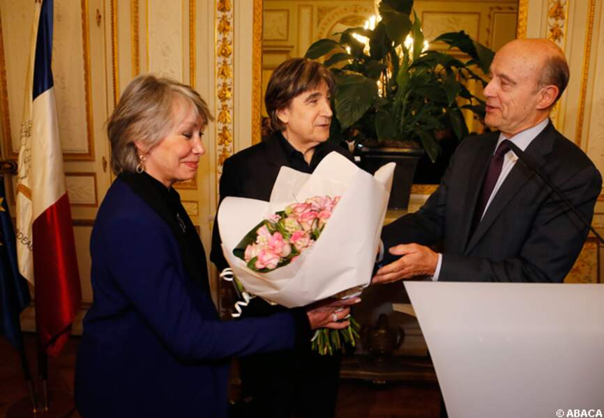 Alain Juppé remet un bouquet de fleurs à la femme de Serge Lama