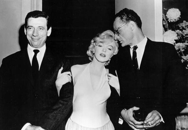 Entre son mari Arthur Miller (à droite) et Yves Montand, à la première du "Milliardaire"