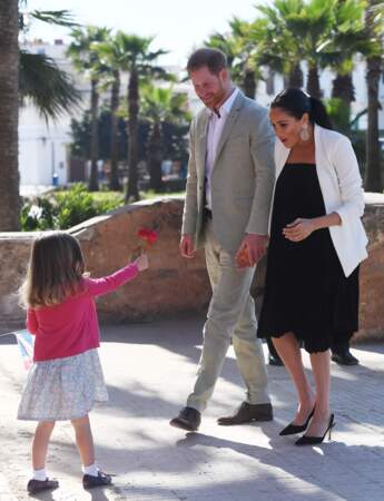 Meghan, touchée par la délicate attention d'une fillette lors de son arrivée aux jardins andalous de Rabat