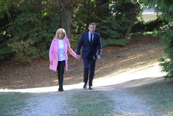 Look noir et blanc sous son manteau rose en cachemire signé Louis Vuitton, Brigitte Macron se distingue.