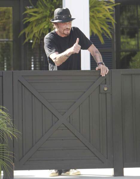 Johnny Hallyday salue les photographes devant sa villa de Pacific Palisades, en septembre 2012