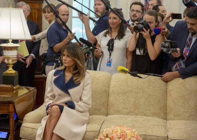 Dans le bureau ovale, face aux médias, Melania Trump prend la pose dans son manteau Gucci.