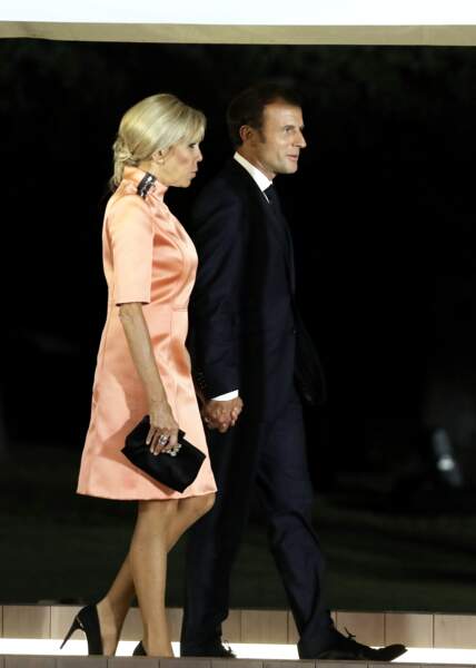 Brigitte Macron très chic avec une pochette noire et une paire d'escarpins noirs
