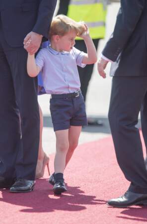 Visiblement impressionné par le tapis rouge et les officiels présents, George ne lâche pas la main de son papa