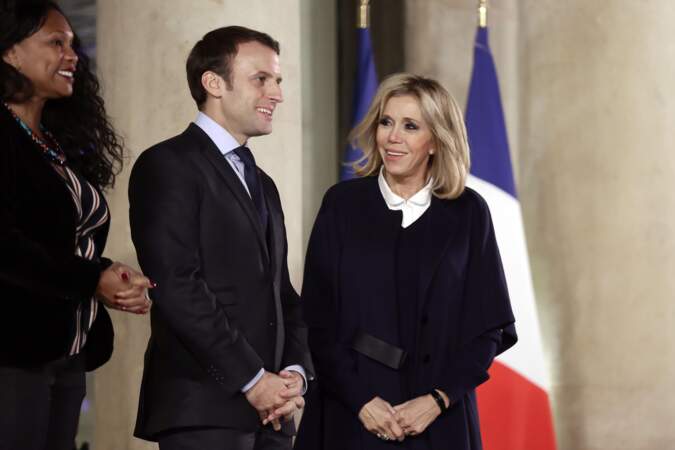 Brigitte Macron très chic avec un manteau bleu sombre ceinturée
