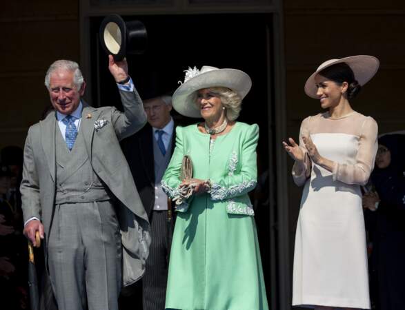 Charles salue la foule, avec Camilla et Meghan à ses côtés, lors de la garden party à Buckingham, le 22 mai 2018