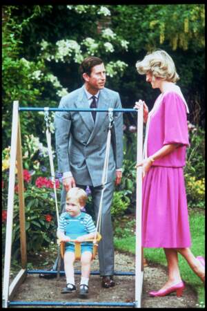 William fait de la balançoire entouré du prince Charles et de Lady Diana, dans les jardins de Kensington en 1984