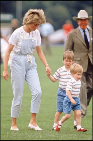 La princesse Diana, en salopette bleu ciel, et ses fils William et Harry, en bermudas et polos rayés, en 1987