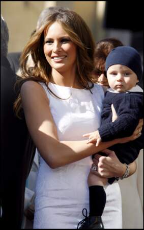 Melania et son fils Baron, lors de la remise de l'étoile de Donald Trump sur le walk of fame à Hollywood, en 2007. Elle porte alors une robe blanche, élégante, près du corps.