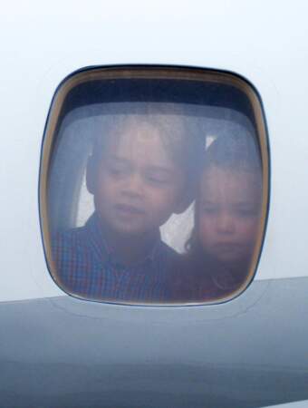 Le prince George et Charlotte regardent du hublot de l'avion