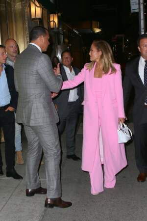 En plus de son costume rose flashy, Jennifer Lopez arborait un mini sac blanc