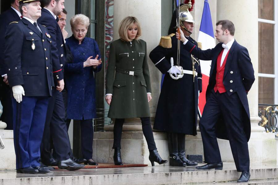 Brigitte Macron en manteau d'officier Louis Vuitton doté de zip, de boutons et ceinturé