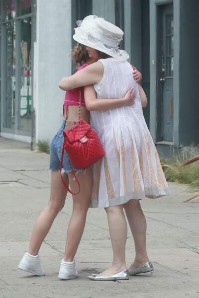 Lily-Rose Depp en look midinette avec un joli haut rose croisé sur la poitrine et un short en jean