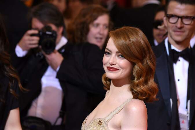 Emma Stone face aux photographes sur le tapis rouge des Oscars