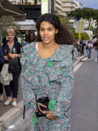 Tina Kunakey en robe fleurie et cheveux noués en queue-de-cheval dans les rues de Cannes