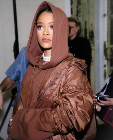 Maquillage glamour sous la capuche d'un sweat complètement marron, Rihanna présente sa collection Fenty x Puma 