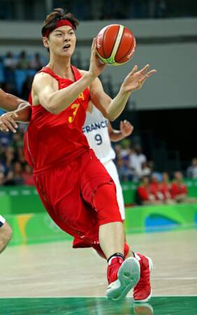 Le basketteur chinois Zhelin Wang, 2,16 mètre, semble être bien effrayé par une si petite balle...