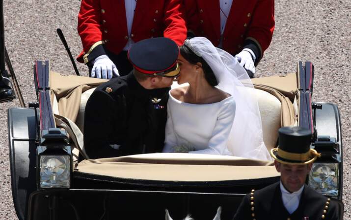 Harry et Meghan échange un baiser, dans la calèche à la sortie du château de Windsor le 19 mai 2018