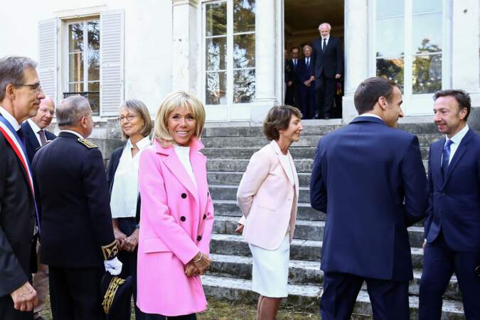 Lumineux, le manteau rose de Brigitte Macron fait ressortir son teint.