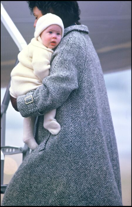 Le prince Harry dans les bras de sa nourrice Barbara Barnes, à l'aéroport d'Aberdeen en Écosse, en 1985