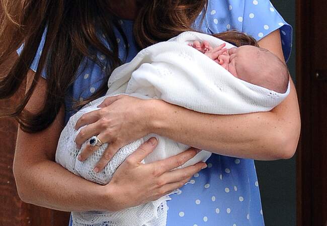 George de Cambridge dans les bras de Kate, à sa sortie de l'hôpital St-Mary à Londres, le 23 juillet 2013