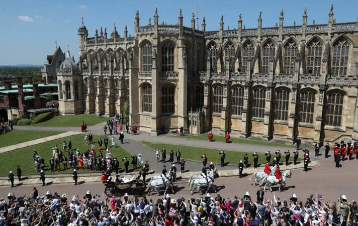 La foule regarde passer le couple royal devant le château de Windsor.