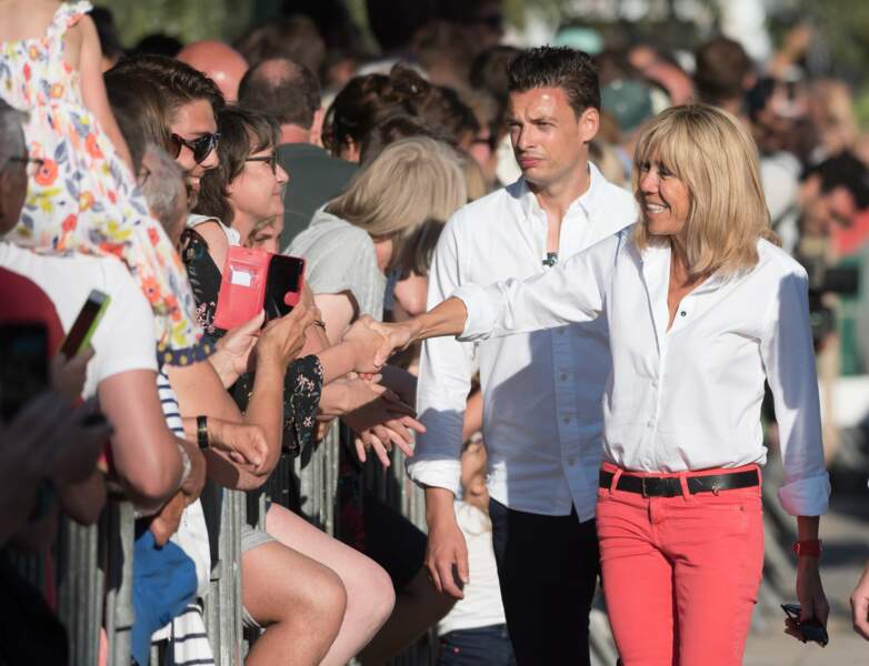 Brigitte Macron en jeans rouge et chemise blanche