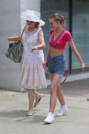 Lily-Rose souriante en grande conversation avec une amie, dans un style vestimentaire estival