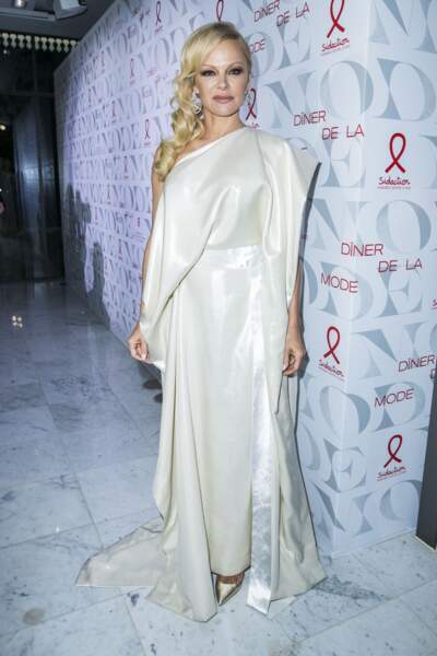 Pamela Anderson, sculpturale en robe blanche soyeuse et bijoux diamantés au Dîner de la mode du Sidaction.