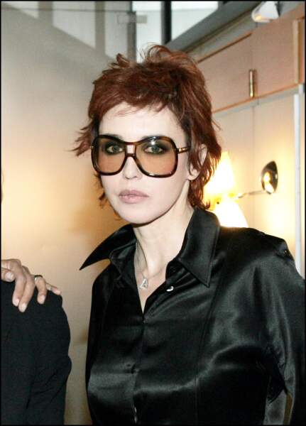 Isabelle Adjani : coupe garçonne auburn et larges lunettes fumées en 2004 à Paris