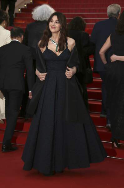 Monica Bellucci avait accessoirisé sa robe très décolleté, avec une cape en faille noir de la maison Dior également