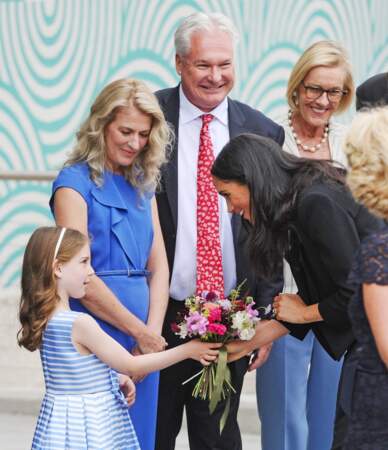 Meghan reçoit un bouquet des mains d'une petite fille au musée de l'émigration à Dublin le 11 juillet 2018