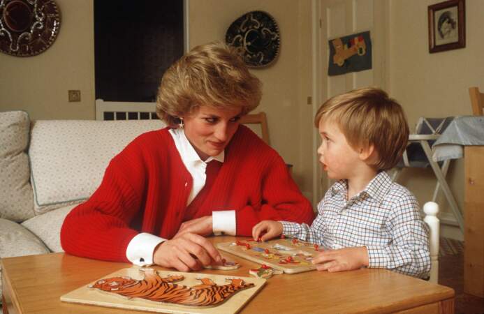 La princesse Lady Diana joue au puzzle avec son fils William dans le palais de Kensington à Londres, en 1985