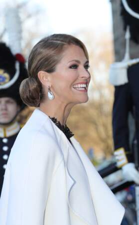 Raie de côté, racines et demi longueurs ultra plaquées et chignon boule laqué pour la Princesse Madeleine de Suède