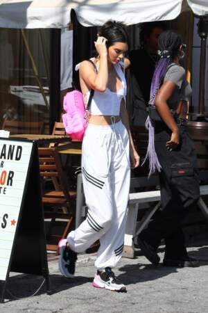 Kendall Jenner en style streetwear casse son allure sport avec un sac à dos rose girly.
