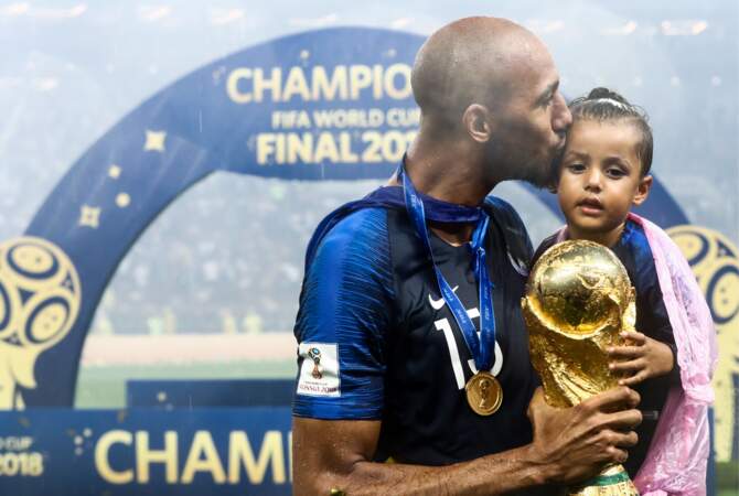 Steven Nzonzi embrasse tendrement sa fille, tandis qu'il porte la Coupe du monde après la victoire des Bleus