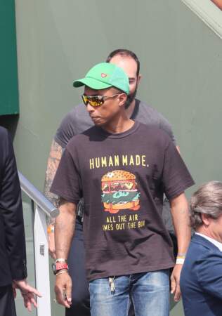 Pharrell Williams avec une casquette verte pour se protéger du soleil