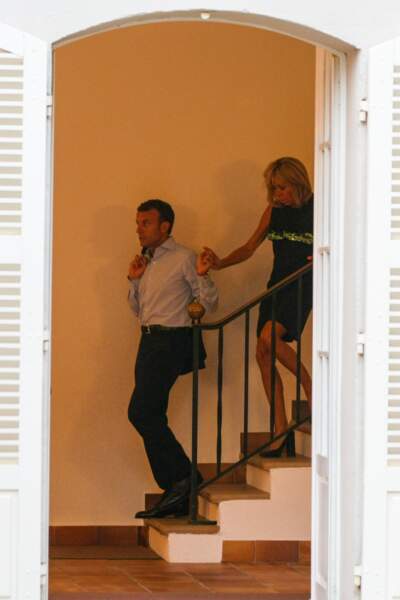 En véritable gentleman, Emmanuel Macron aide sa femme à descendre les escaliers.