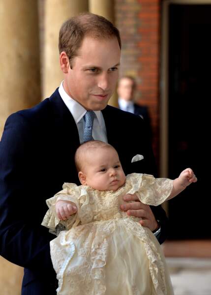 Le prince George dans les bras de son père William d'Angleterre lors de son baptême, le 23 octobre 2013 à Londres