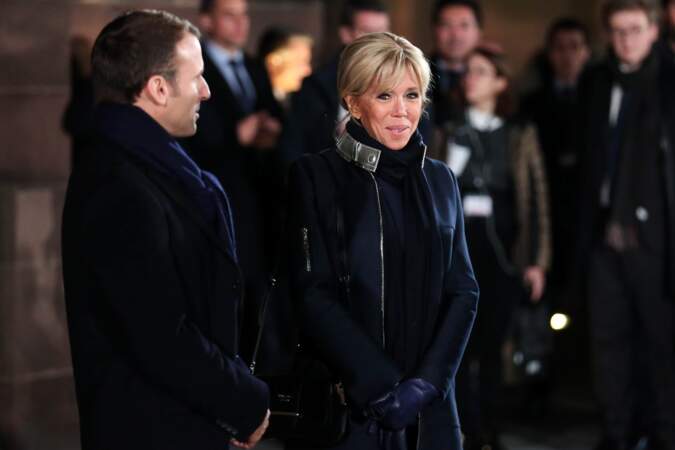 Le manteau bleu marine aux liserés argentés de Brigitte Macron est signé Louis Vuitton. 