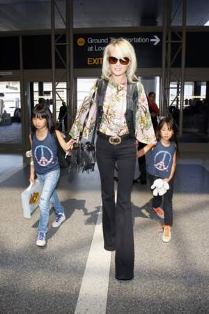 Laeticia Hallyday en blouse imprimée, sac à franges et pantalon bootcut, avec Jade et Joy à Los Angeles en 2015