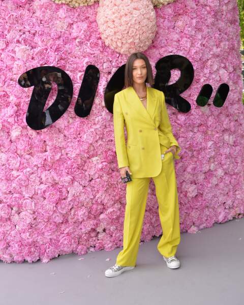 Bella Hadid, solaire dans son costume oversize jaune qui nous inspire devant le photocall Dior Homme.