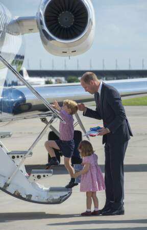 Le Prince William aidant ses enfants à monter dans l'avion