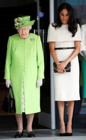 Meghan Markle en blanc très clair à côté de al tenue très colorée de la reine