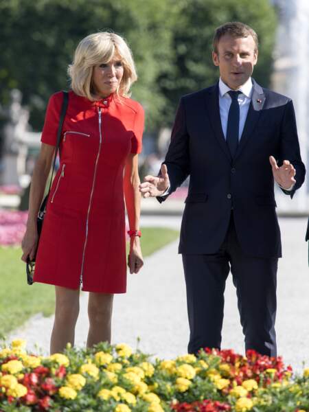 Brigitte Macron radieuse en robe rouge zippée, qu'elle a en plusieurs couleurs, et son mari Emmanuel Macron